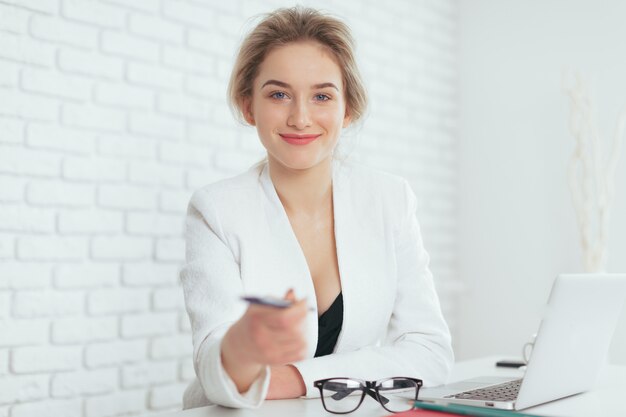 Portret van mooie jonge vrouw die in het bureau werkt.