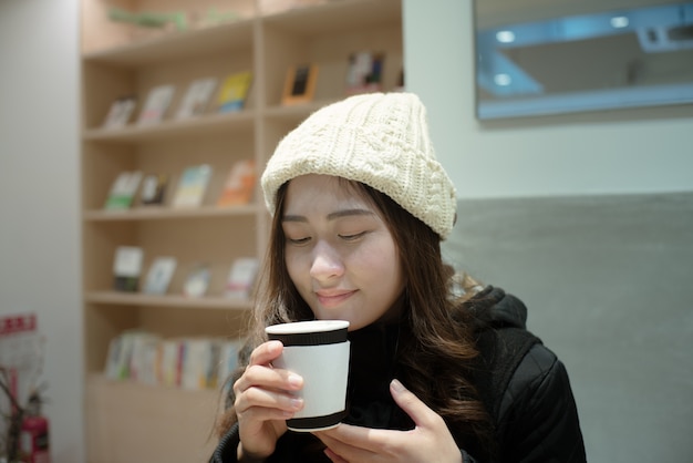 Foto portret van mooie jonge vrouw drinken en koffie ruiken thuis