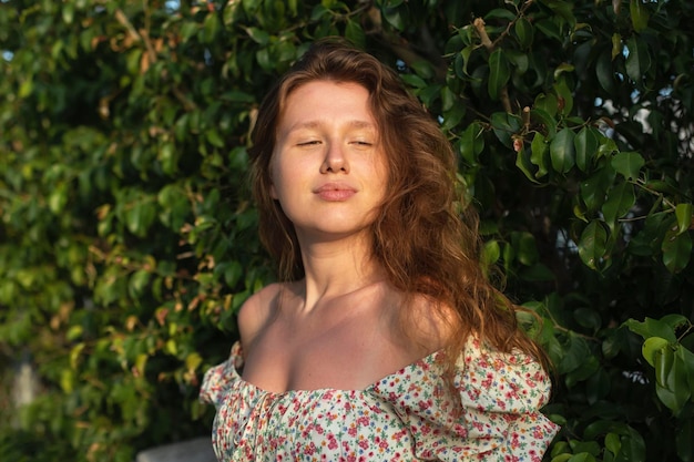 Portret van mooie jonge vrouw in jurk geniet van zomer- of lentedag op natuurlijk groen natuurlijk