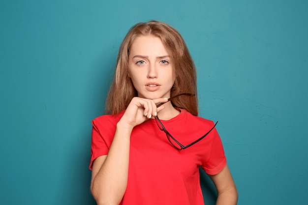 Portret van mooie jonge vrouw met een bril op kleur background