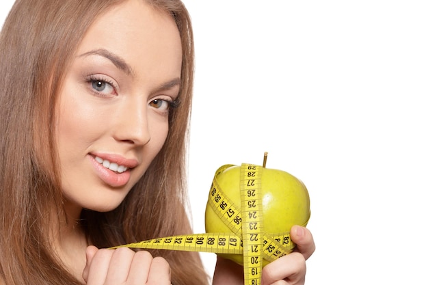 Portret van mooie jonge vrouw met groene appel en meten