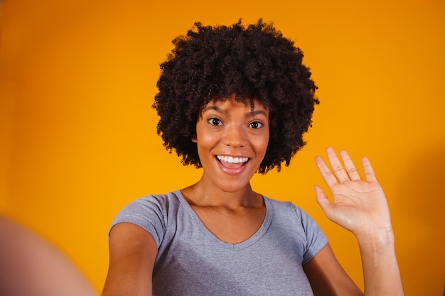 Portret van mooie jonge zwarte vrouw die selfie maakt.