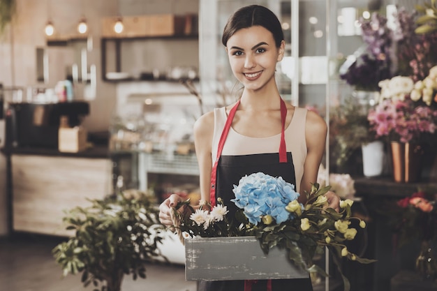 Portret van mooie meisjesbloemist in bloemwinkel