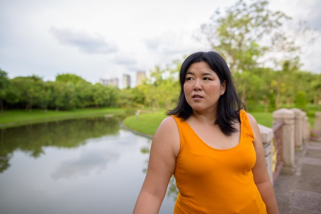 Portret van mooie overgewicht Aziatische vrouw ontspannen in het park in de stad Bangkok, Thailand