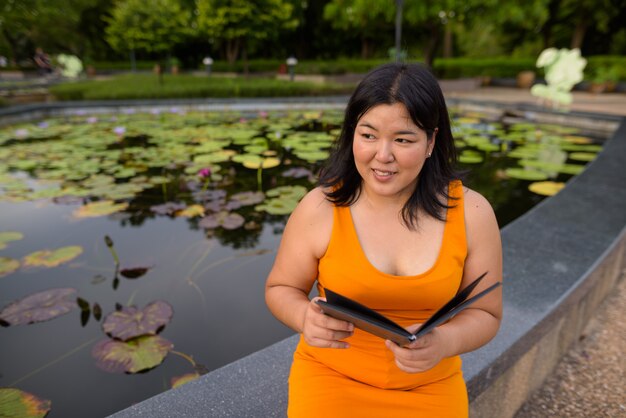 Portret van mooie overgewicht Aziatische vrouw ontspannen in het park in de stad Bangkok, Thailand