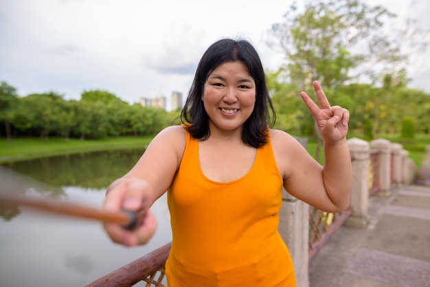 Portret van mooie overgewicht Aziatische vrouw ontspannen in het park in de stad Bangkok, Thailand