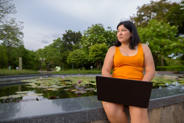 Portret van mooie overgewicht Aziatische vrouw ontspannen in het park in de stad Bangkok, Thailand