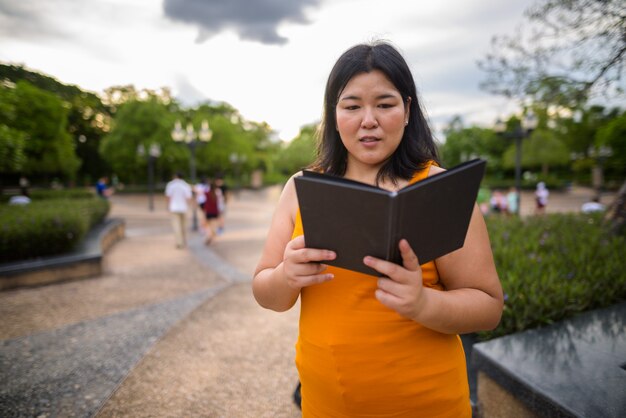 Portret van mooie overgewicht Aziatische vrouw ontspannen in het park in de stad Bangkok, Thailand