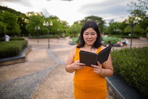 Portret van mooie overgewicht Aziatische vrouw ontspannen in het park in de stad Bangkok, Thailand