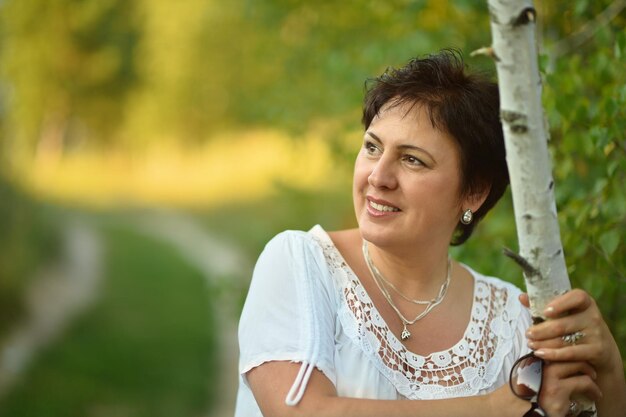 Portret van mooie rijpe vrouw die van de zomer in openlucht geniet