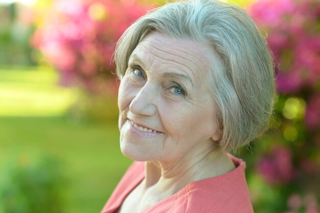 Portret van mooie senior vrouw buiten in zomer park