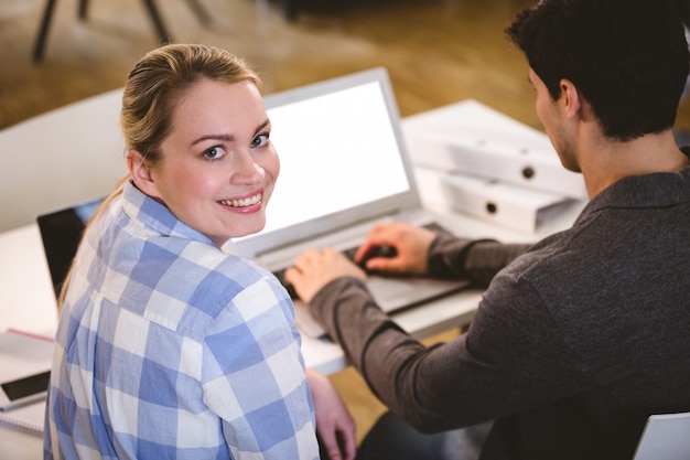 Foto portret van mooie stafmedewerker met collega die aan laptop op creatief kantoor werken