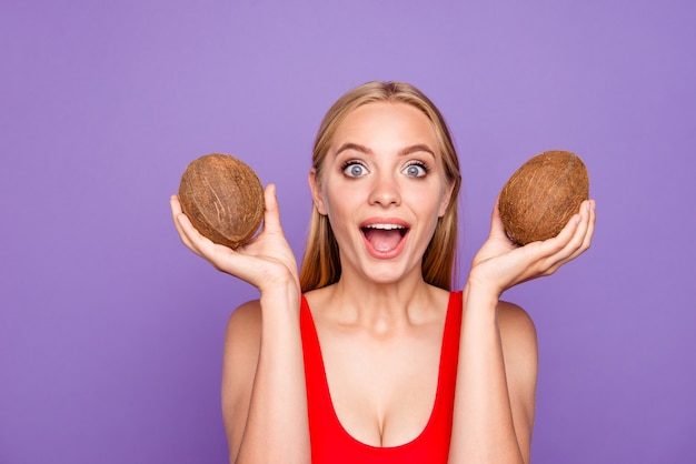 Portret van mooie verrukkelijke dame twee kokosnoten in handen houden