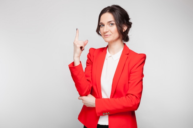 Portret van mooie vrouw in rode blazer die tekens toont