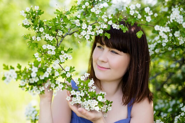 Portret van mooie vrouw met bloeiende boom in de lente of zomertuin