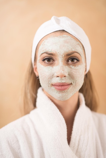 portret van mooie vrouw met cosmetisch masker op gezicht in spa- en wellnesssalon