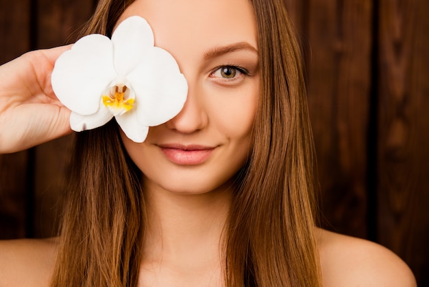 Portret van mooie vrouw met een orchidee