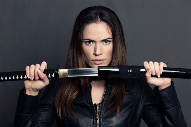 Portret van mooie vrouw met Katana in studio