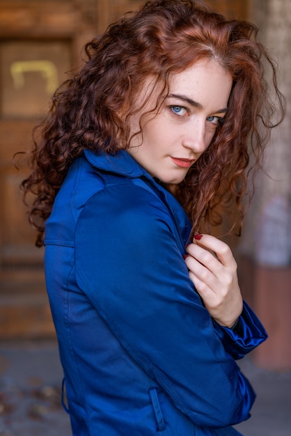 Portret van mooie vrouw met rood haar in blauwe mantel