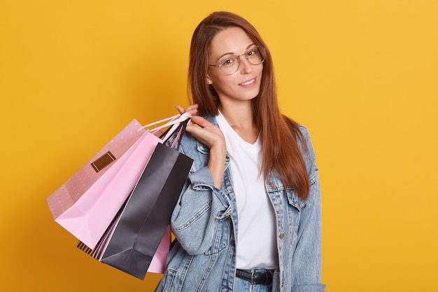 Portret van mooie vrouw met steil haar met roze en zwarte boodschappentassen