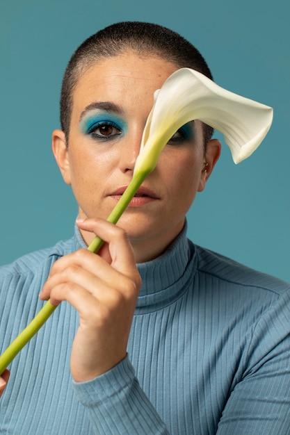 Portret van mooie vrouw poserend in een coltrui met een bloem