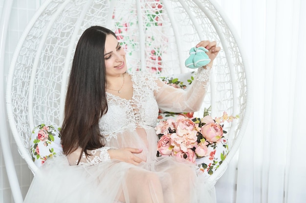 Portret van mooie zwangere vrouw poseren met bloemen