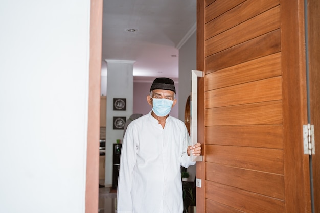 Portret van moslim volwassen man wachten op familie om naar huis te komen met masker tijdens eid mubarak