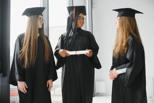 Portret van multiraciale afgestudeerden met diploma