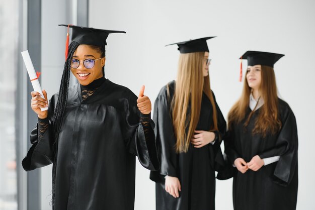 Portret van multiraciale afgestudeerden met diploma