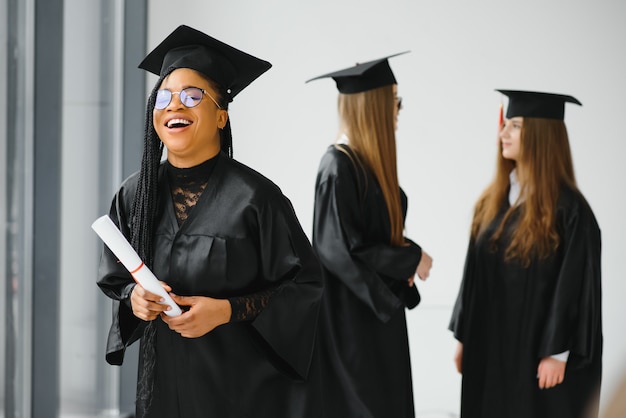 Portret van multiraciale afgestudeerden met diploma