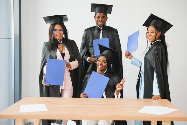 Portret van multiraciale afgestudeerden met diploma