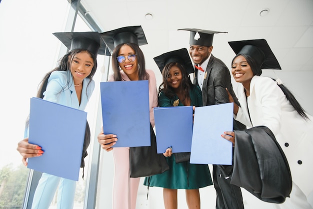 Portret van multiraciale afgestudeerden met diploma