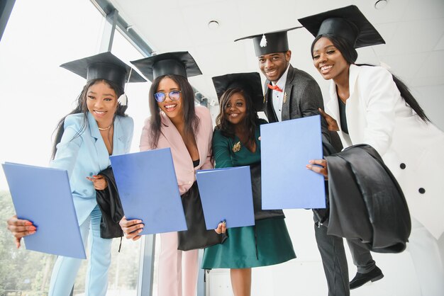 Portret van multiraciale afgestudeerden met diploma