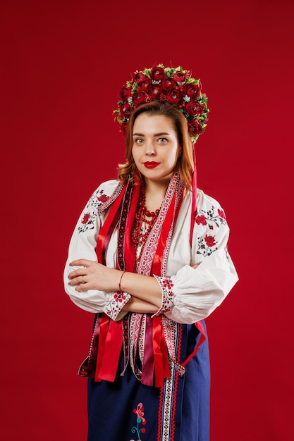 Portret van Oekraïense vrouw in traditionele etnische kleding en bloemen rode krans op viva magenta studio achtergrond Oekraïense nationale geborduurde jurk oproep vyshyvanka Bid voor Oekraïne