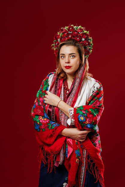 Portret van Oekraïense vrouw in traditionele etnische kleding en bloemen rode krans op viva magenta studio achtergrond Oekraïense nationale geborduurde jurk oproep vyshyvanka Bid voor Oekraïne