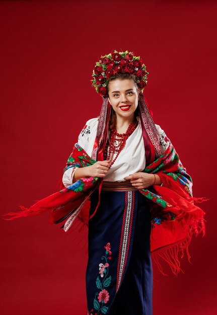 Portret van Oekraïense vrouw in traditionele etnische kleding en bloemen rode krans op viva magenta studio achtergrond Oekraïense nationale geborduurde jurk oproep vyshyvanka Bid voor Oekraïne