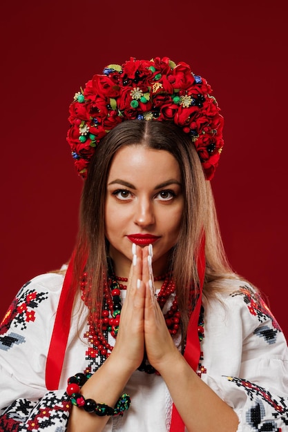 Portret van Oekraïense vrouw in traditionele etnische kleding en bloemen rode krans op viva magenta studio achtergrond Oekraïense nationale geborduurde jurk oproep vyshyvanka Bid voor Oekraïne