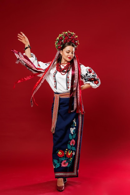 Foto portret van oekraïense vrouw in traditionele etnische kleding en bloemen rode krans op viva magenta studio achtergrond oekraïense nationale geborduurde jurk oproep vyshyvanka bid voor oekraïne