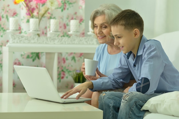 Portret van oma en jongen met laptop in de kamer