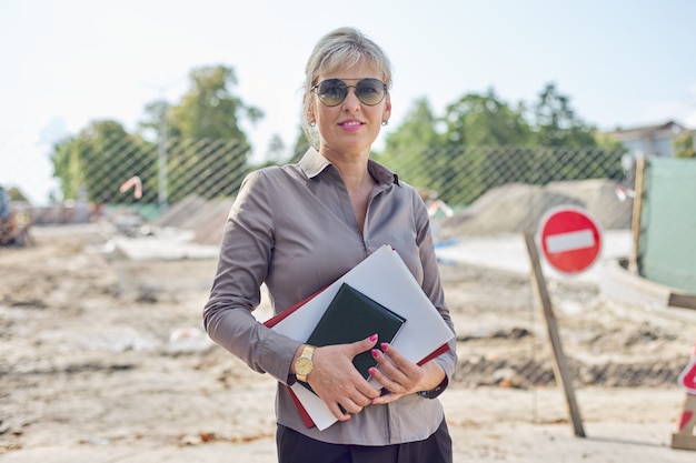 Portret van onderneemster op bouwwerf die weg herstellen