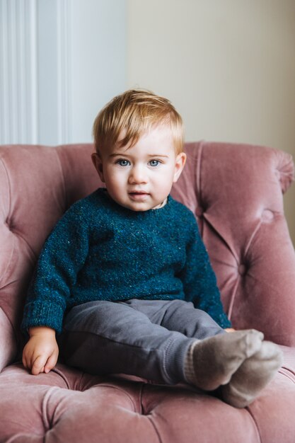 Portret van onschuldig klein kind met blauwe ogen en dikke wangen, kijkt rechtstreeks in de camera