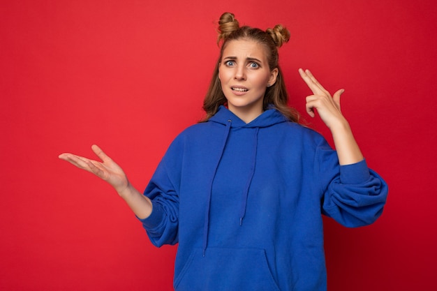 Portret van ontevreden vermoeide jonge, mooie blonde vrouw met twee hoorns met oprechte