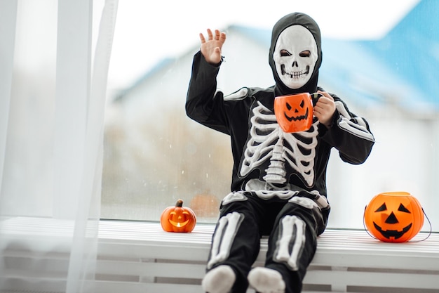 Portret van openhartige authentieke gen Z-jongen veel plezier in skeletkostuum tijdens Halloween-vakantie