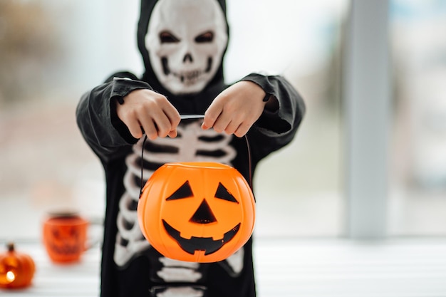 Portret van openhartige authentieke gen Z-jongen veel plezier in skeletkostuum tijdens Halloween-vakantie