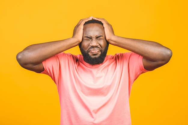 Portret van opgewonden jonge Afro-Amerikaanse man schreeuwen in shock en verbazing hand in hand op het hoofd.