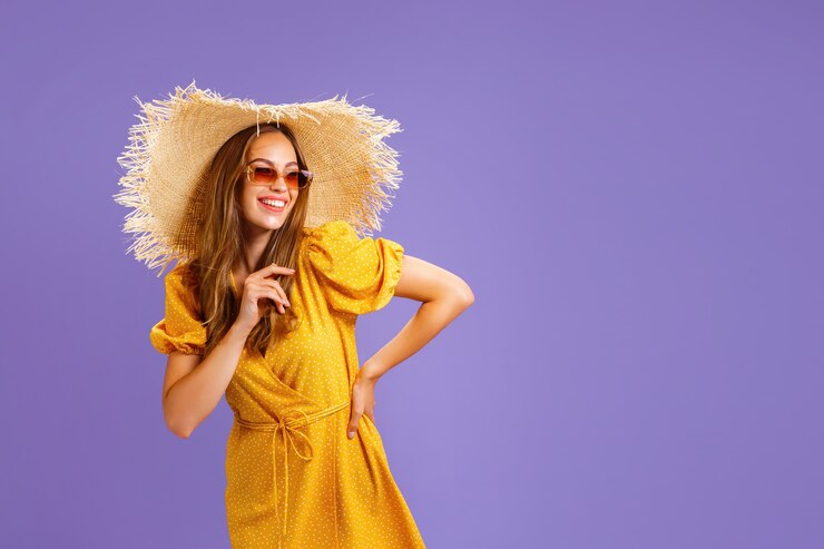 Portret van opgewonden jonge vrouw in gele jurk zomer hoed zonnebril poseren geïsoleerd op pastel viol...