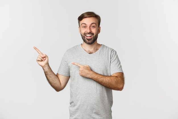 Portret van opgewonden lachende man met baard, casual grijs t-shirt dragen