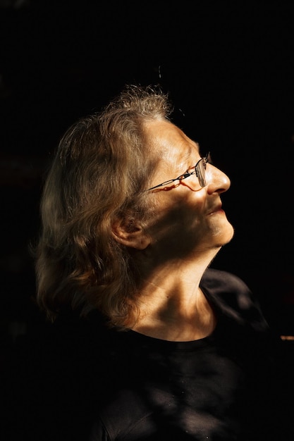 Portret van oudere vrouw in glazen close-up op natuurlijke achtergrond Profiel van man met zonsondergang zonlicht op zijn gezicht