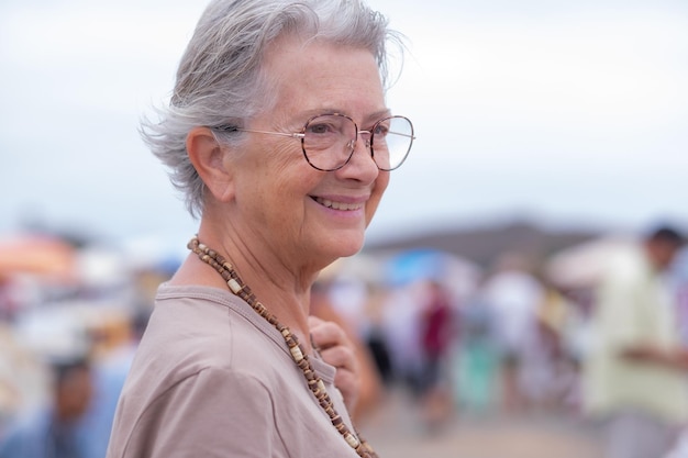 Portret van oudere vrouw op de rommelmarkt op zoek naar tweedehands kleding, petten, schoenen, tassen Zero waste shopping eco-vriendelijk concept duurzame levensstijl