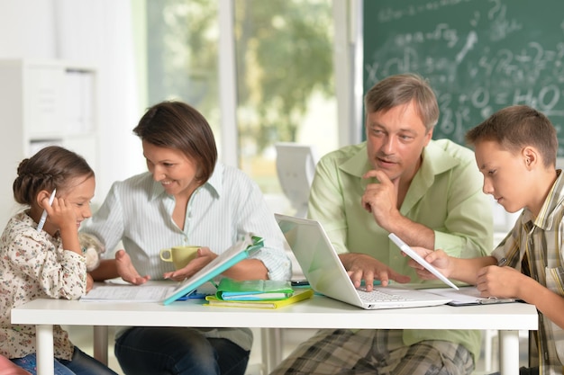 Portret van ouders die hun kinderen helpen hun huiswerk in de klas te maken